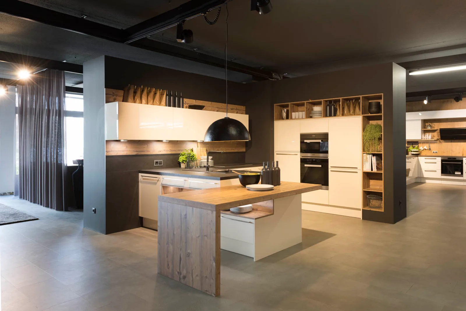 Weiße Hochglanzküche mit Holztheke und offener Regalwand im Showroom
